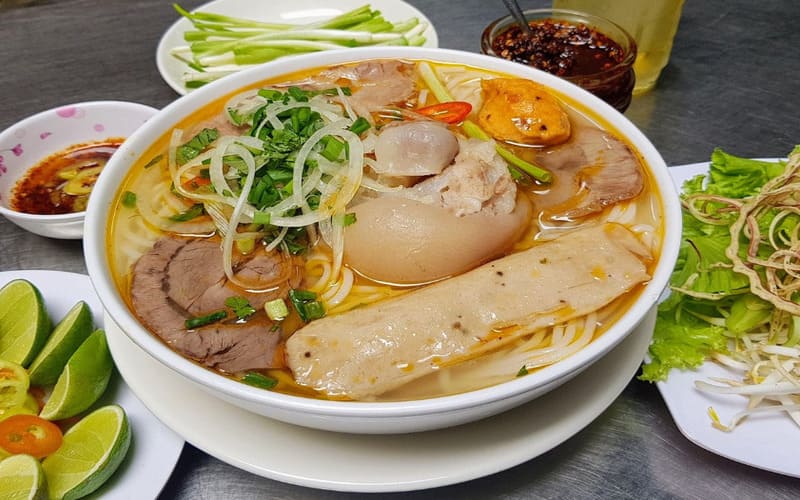 Tô bún bò Huế với nước dùng đậm đà, thịt bò thái lát, chả và giò heo mềm.