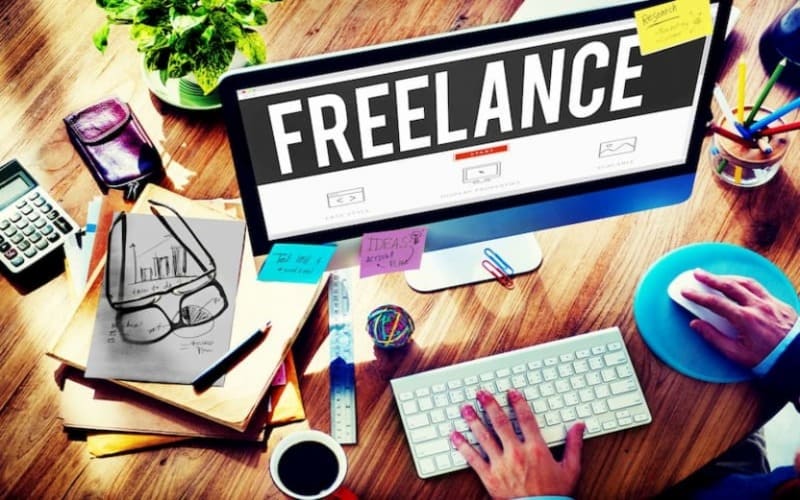 Khu vực làm việc của một freelancer với máy tính, tài liệu, giấy note