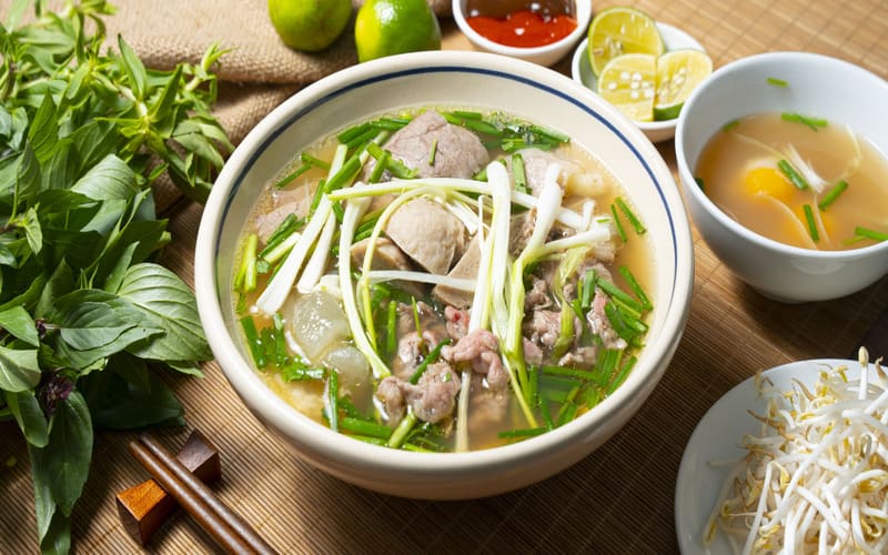 Tô phở Gia Truyền Bếp Nhà với nước dùng trong, bò viên, thịt bò thái mỏng vừa, cùng rau sống, giá ăn kèm